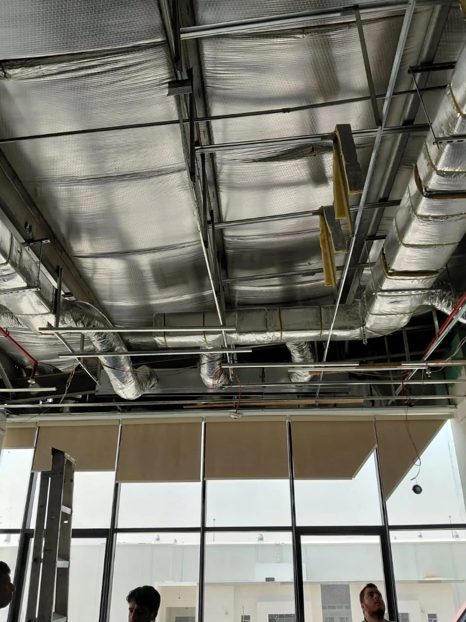 Insulated rectangular ductwork installed above a ceiling before finishing